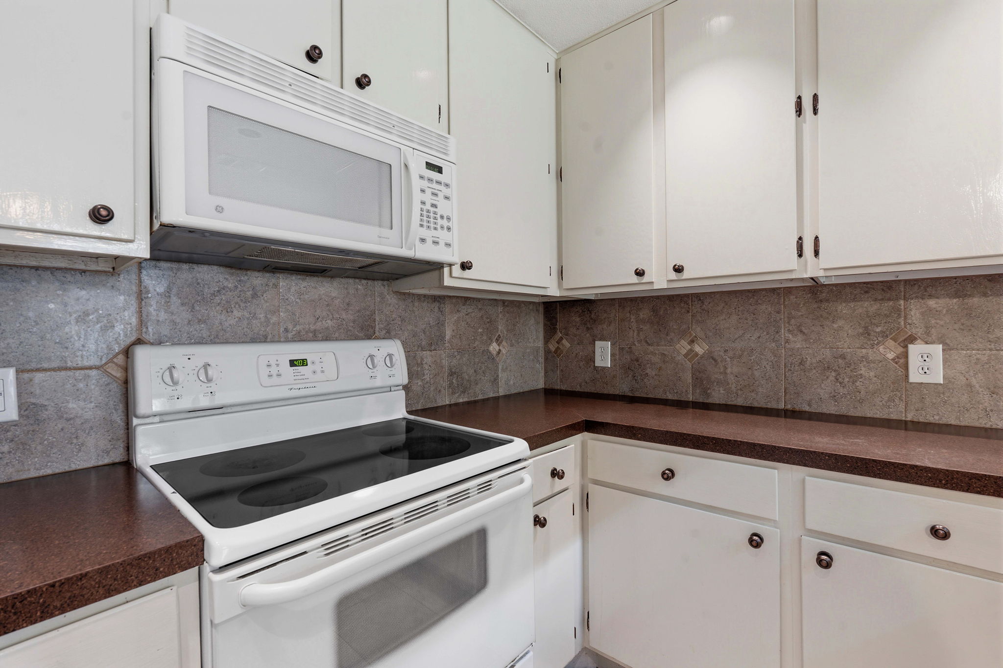 1748 Ohlen Road, Unit 24 Austin, TX 78757 - Photo 11 of 30 a kitchen with white cabinets and white appliances