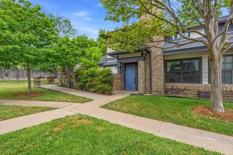 a view of a house with a tree in front of it