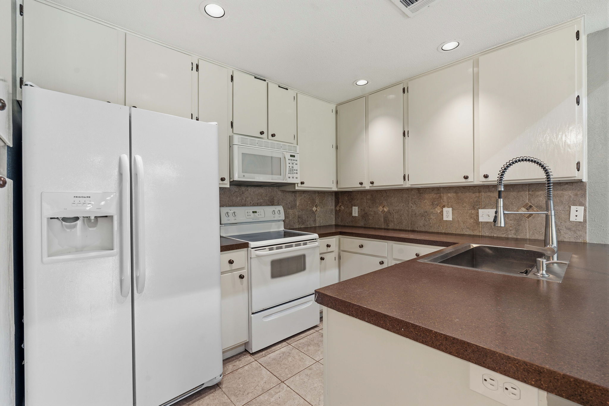 1748 Ohlen Road, Unit 24 Austin, TX 78757 - Photo 10 of 30 a kitchen with stainless steel appliances granite countertop a refrigerator sink and white cabinets