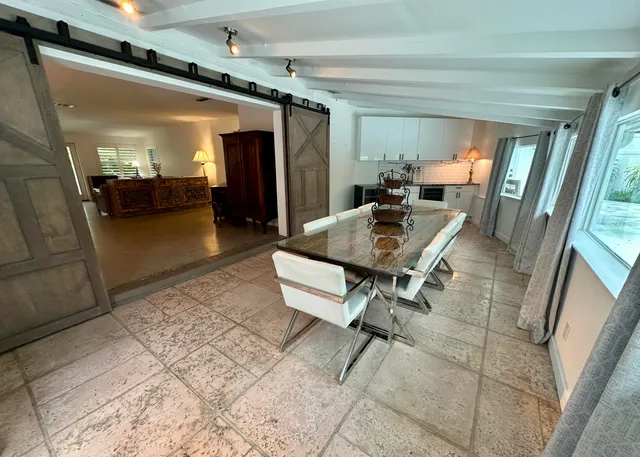 a kitchen with stainless steel appliances granite countertop a refrigerator a stove a sink and white cabinets with wooden floor