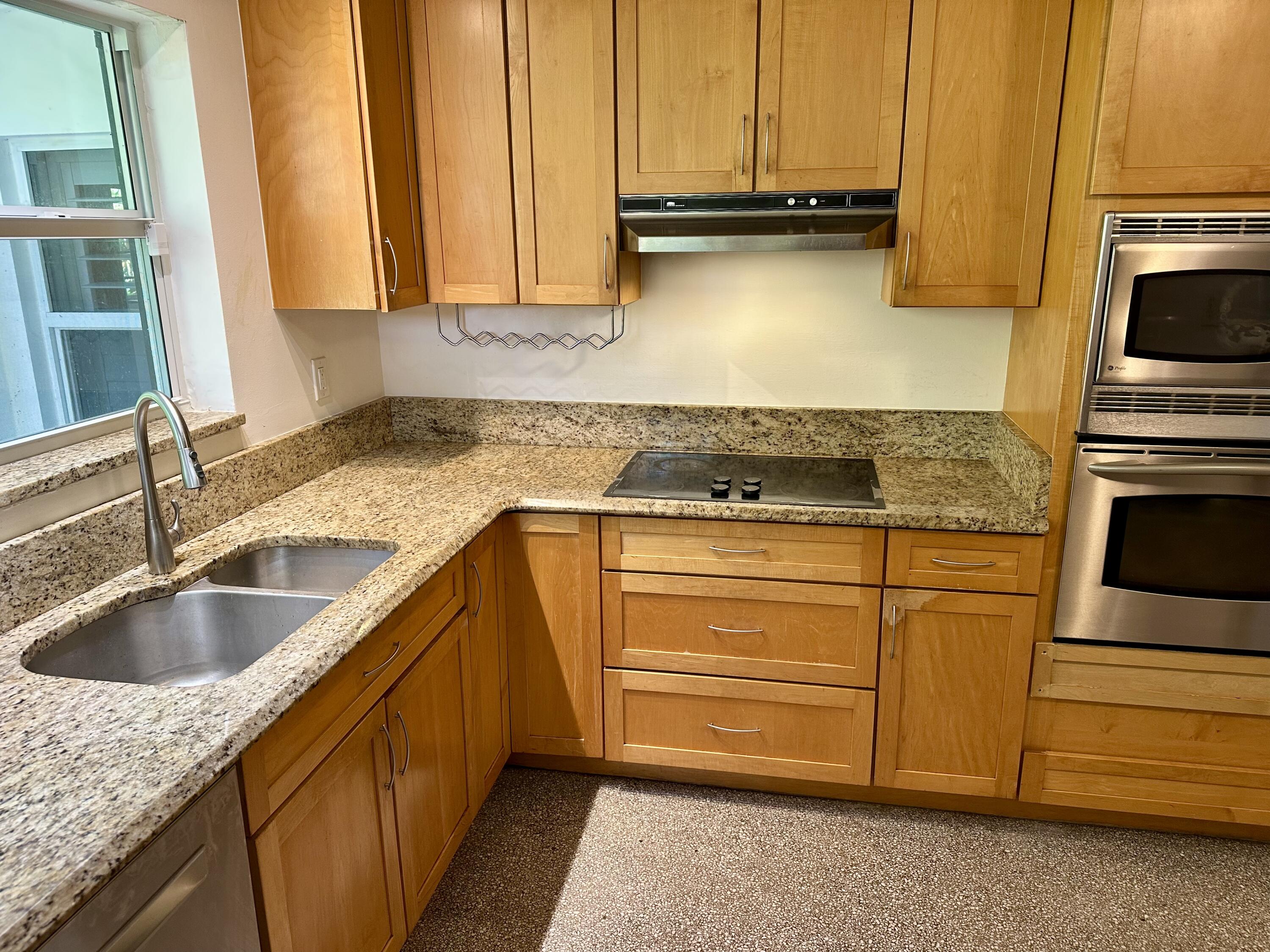 212 Kings Lynn Delray Beach, FL 33444 - Photo 21 of 53 a kitchen with granite countertop a sink and cabinets