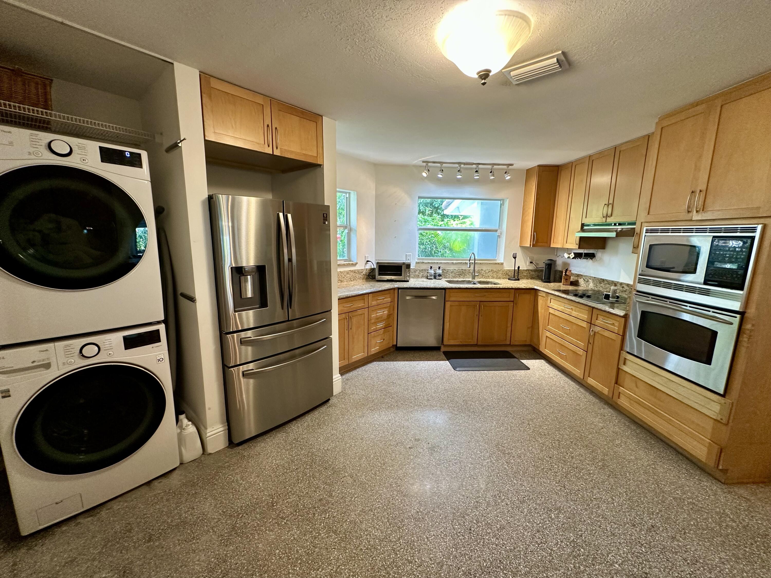 212 Kings Lynn Delray Beach, FL 33444 - Photo 22 of 53 a kitchen with stainless steel appliances granite countertop a refrigerator a stove top oven a sink and dishwasher