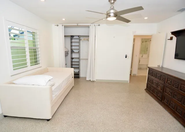 a large bed sitting in a bedroom next to a window
