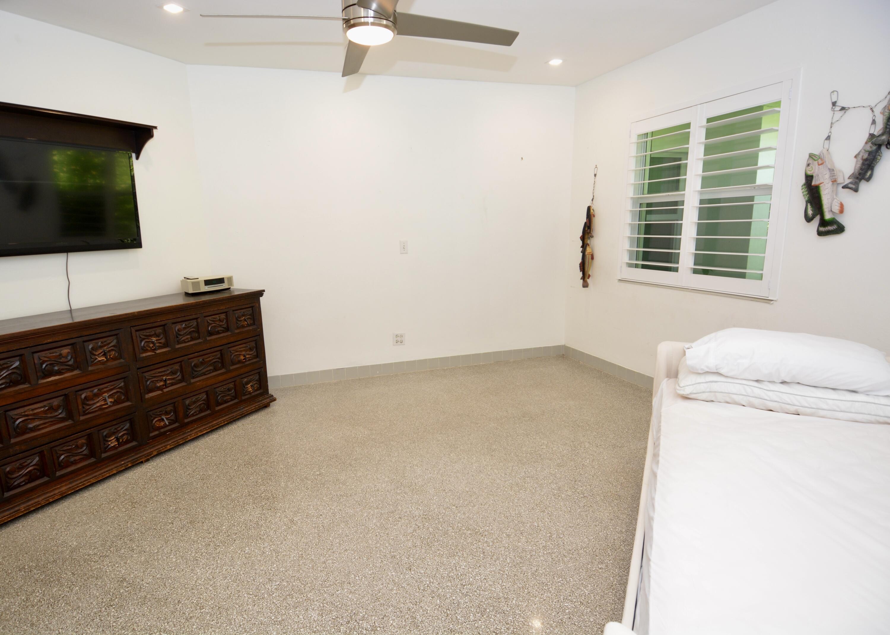 212 Kings Lynn Delray Beach, FL 33444 - Photo 31 of 53 a room with a bed and a flat screen tv