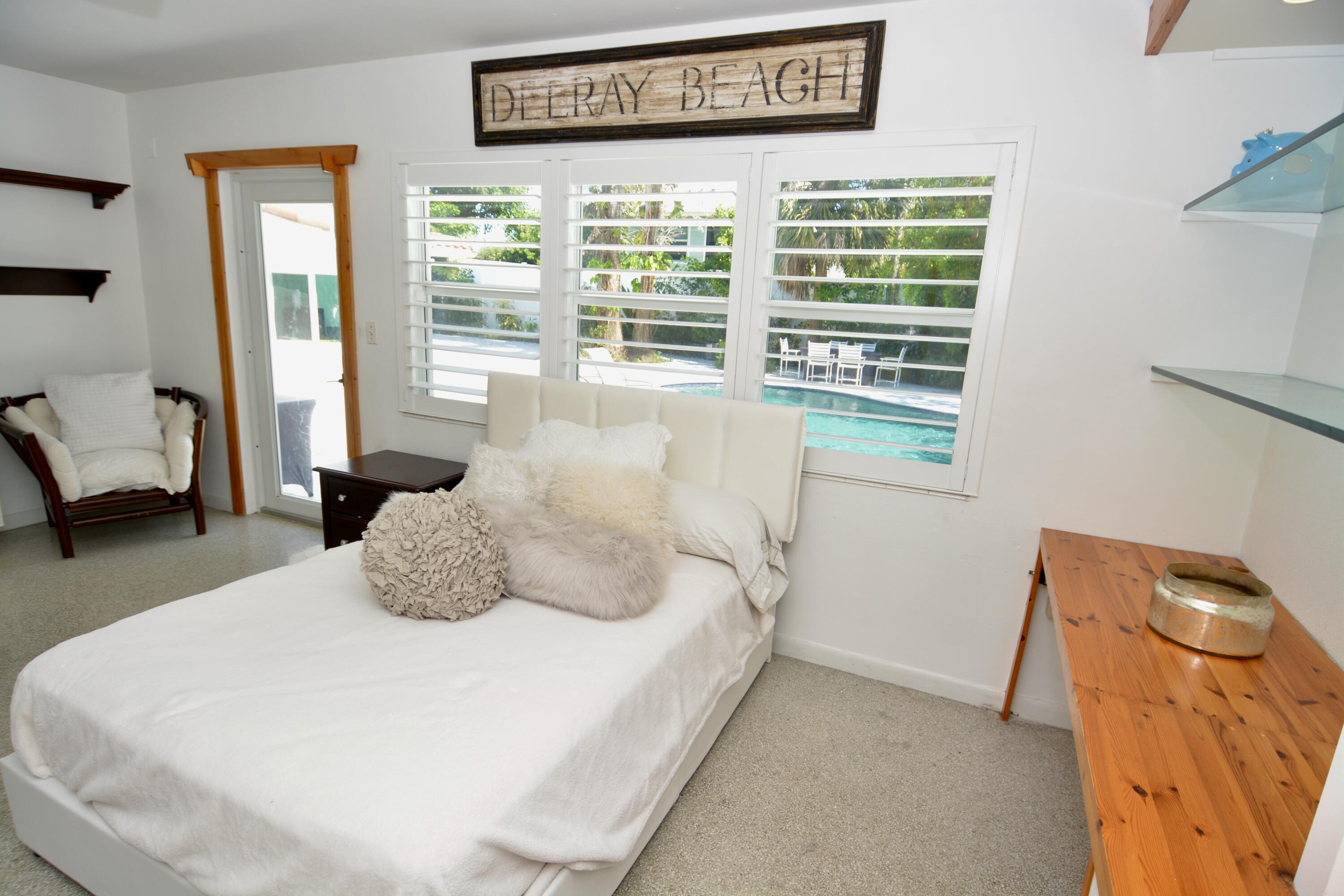 212 Kings Lynn Delray Beach, FL 33444 - Photo 35 of 53 a large bed sitting in a bedroom next to a window