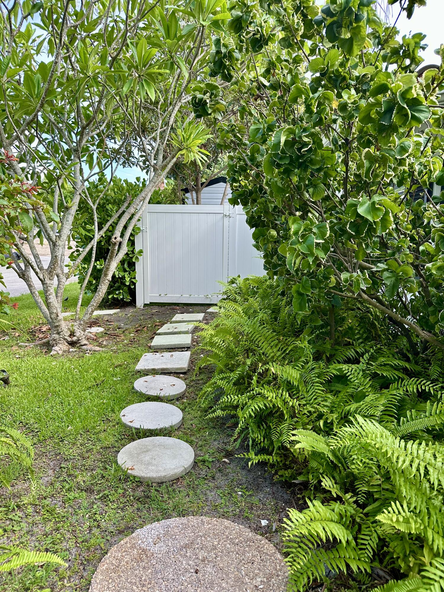 212 Kings Lynn Delray Beach, FL 33444 - Photo 47 of 53 a backyard of a house with plants and outdoor seating