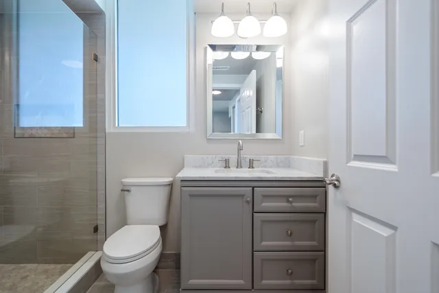 a bathroom with a shower a toilet and a sink