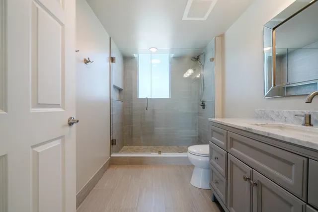 a bathroom with a sink a toilet and shower