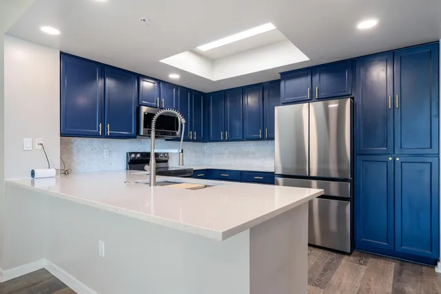 a kitchen with stainless steel appliances granite countertop a refrigerator and a sink