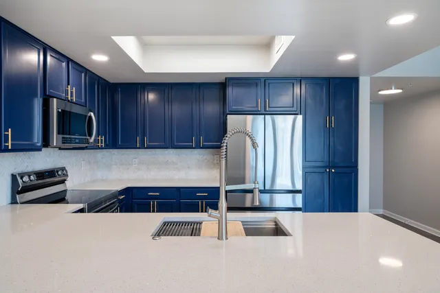 a kitchen with kitchen island granite countertop wooden cabinets a refrigerator and a sink