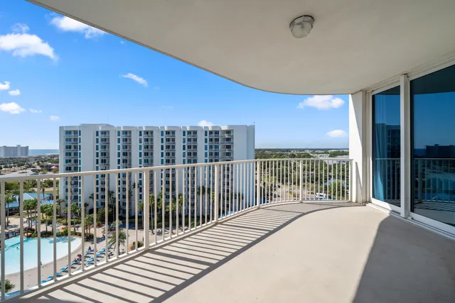 a balcony with a floor to ceiling window and wooden floor