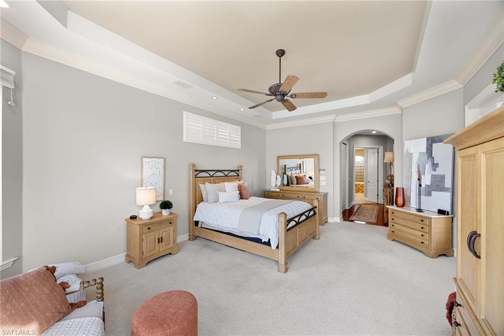 1942 Kingfish Road Naples, FL 34102 - Photo 25 of 50 a spacious bedroom with a bed couch chandelier and a window