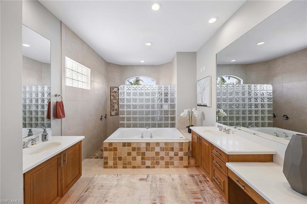 1942 Kingfish Road Naples, FL 34102 - Photo 26 of 50 a bathroom with a tub sink and mirror