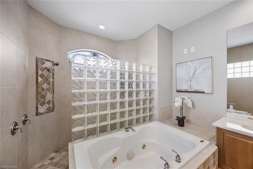 1942 Kingfish Road Naples, FL 34102 - Photo 27 of 50 a bathroom with a bathtub sink and mirror