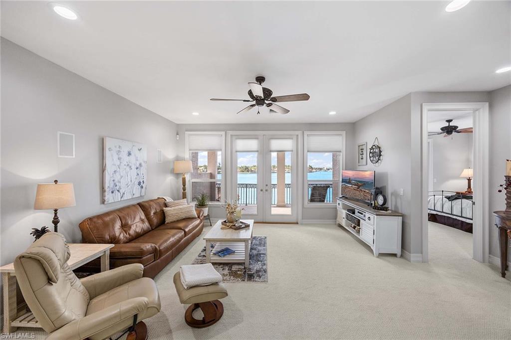 1942 Kingfish Road Naples, FL 34102 - Photo 34 of 50 a living room with furniture a large window and gym equipment