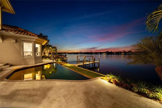 a view of a swimming pool with seating area and lake view