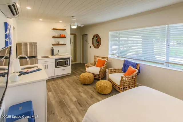 a bedroom with furniture and a large window