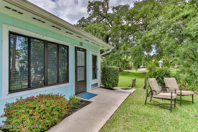 a view of a chair and table in backyard of the house