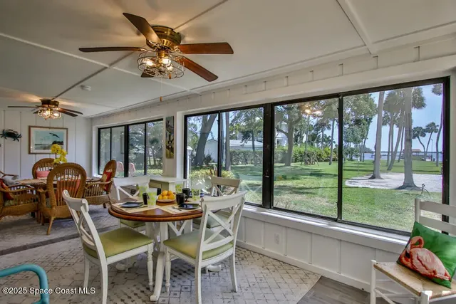 a dining room with furniture water view and a floor to ceiling window