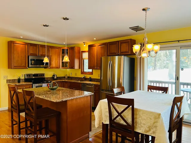 a kitchen with a table chairs refrigerator and microwave