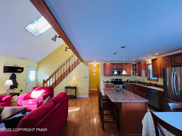 a kitchen with stainless steel appliances granite countertop a refrigerator a stove top oven a sink and dishwasher