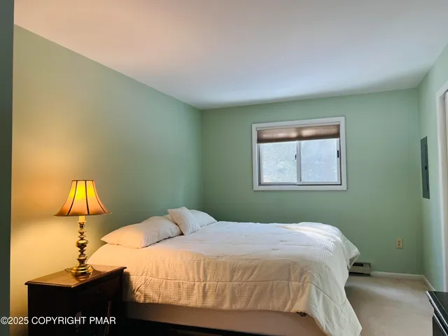 a bedroom with a bed and a painting on the wall