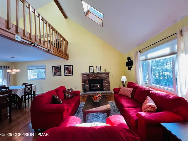 a living room with furniture fireplace and a large window