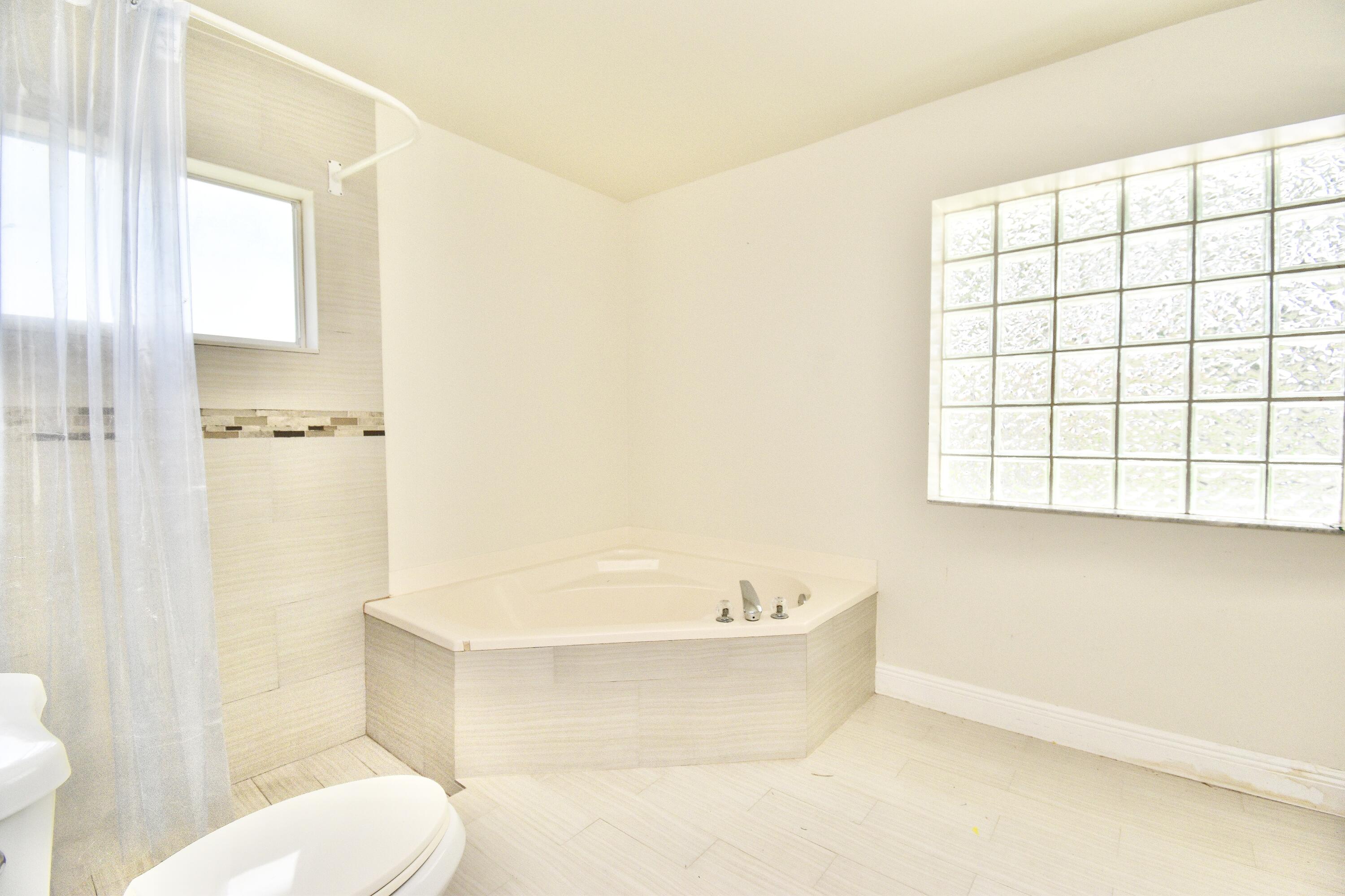 6053 Old Court Road, Unit 308 Boca Raton, FL 33433 - Photo 11 of 22 a bathroom with a bathtub and toilet