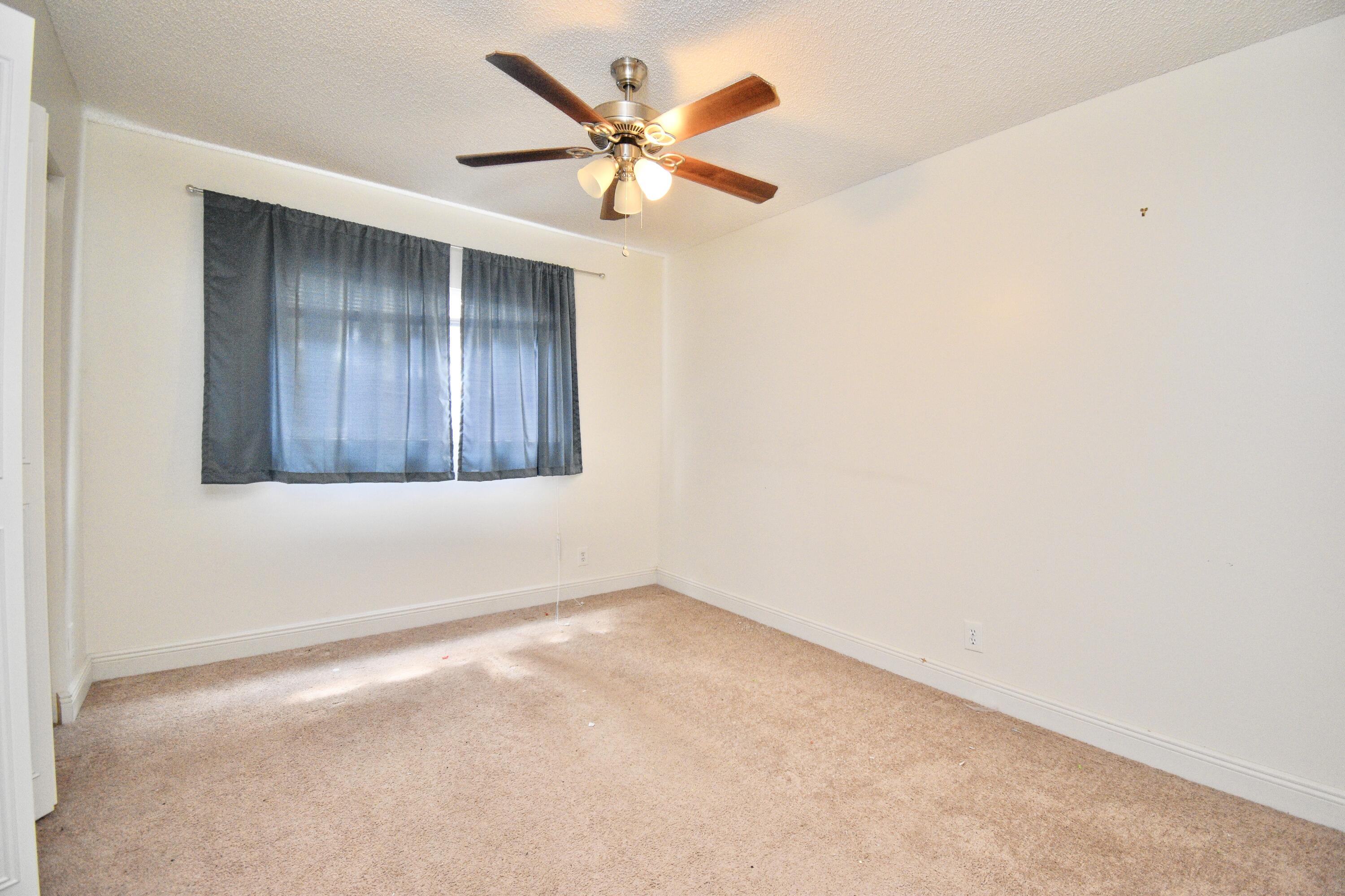6053 Old Court Road, Unit 308 Boca Raton, FL 33433 - Photo 15 of 22 an empty room with a ceiling fan and wooden floor