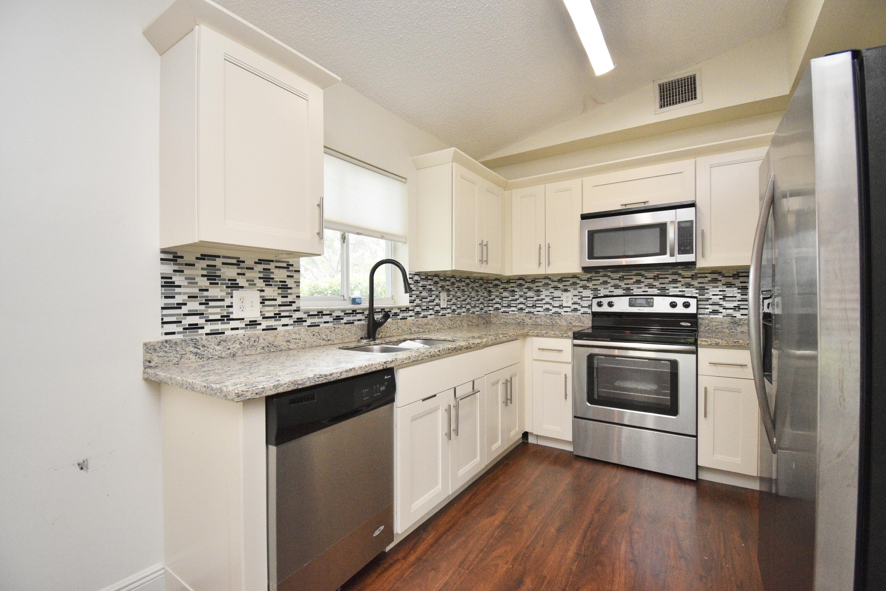 6053 Old Court Road, Unit 308 Boca Raton, FL 33433 - Photo 18 of 22 a kitchen with a sink stove and microwave