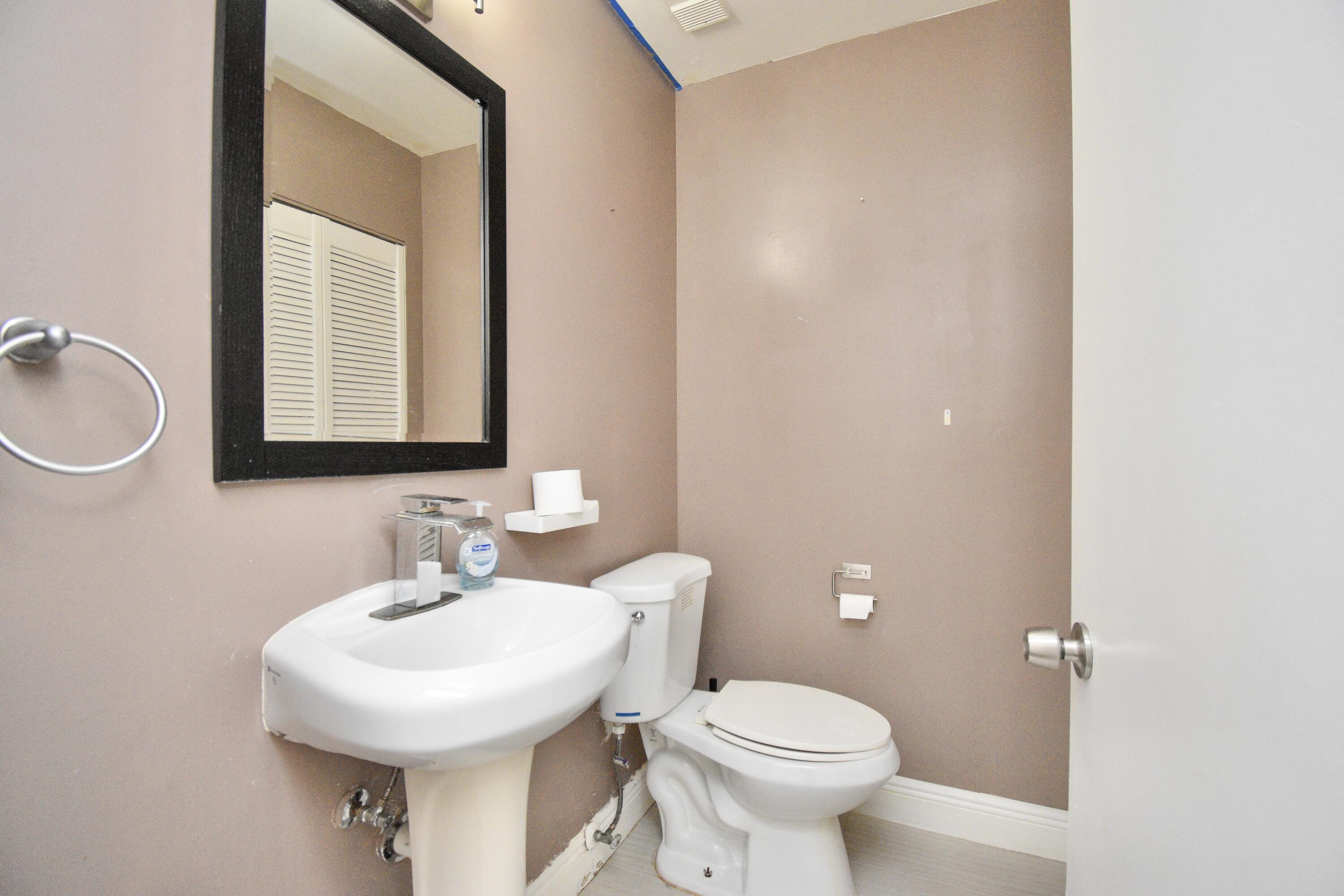 6053 Old Court Road, Unit 308 Boca Raton, FL 33433 - Photo 19 of 22 a bathroom with a toilet a sink and mirror