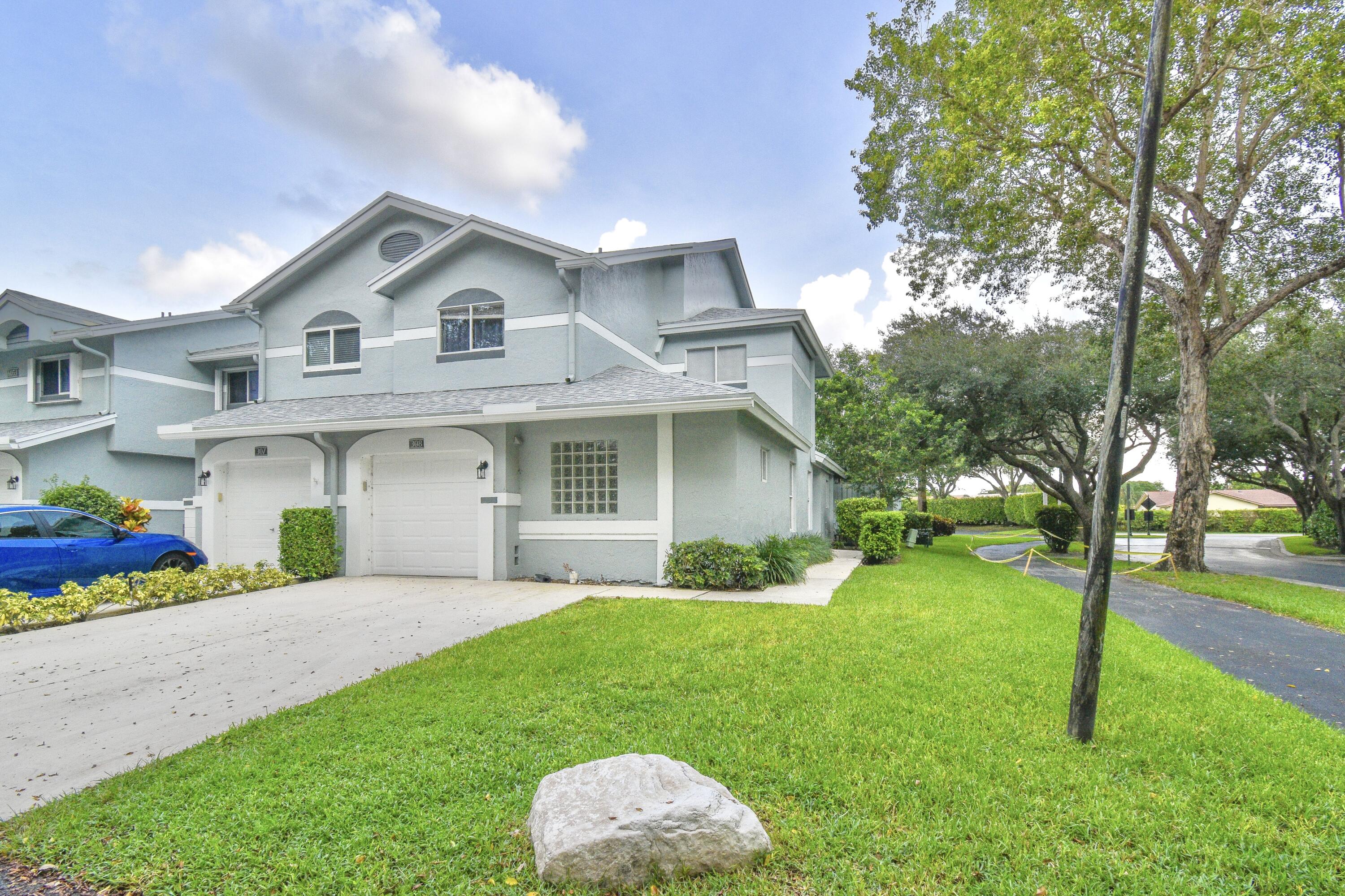 6053 Old Court Road, Unit 308 Boca Raton, FL 33433 - Photo 2 of 22 a front view of a house with a yard and trees