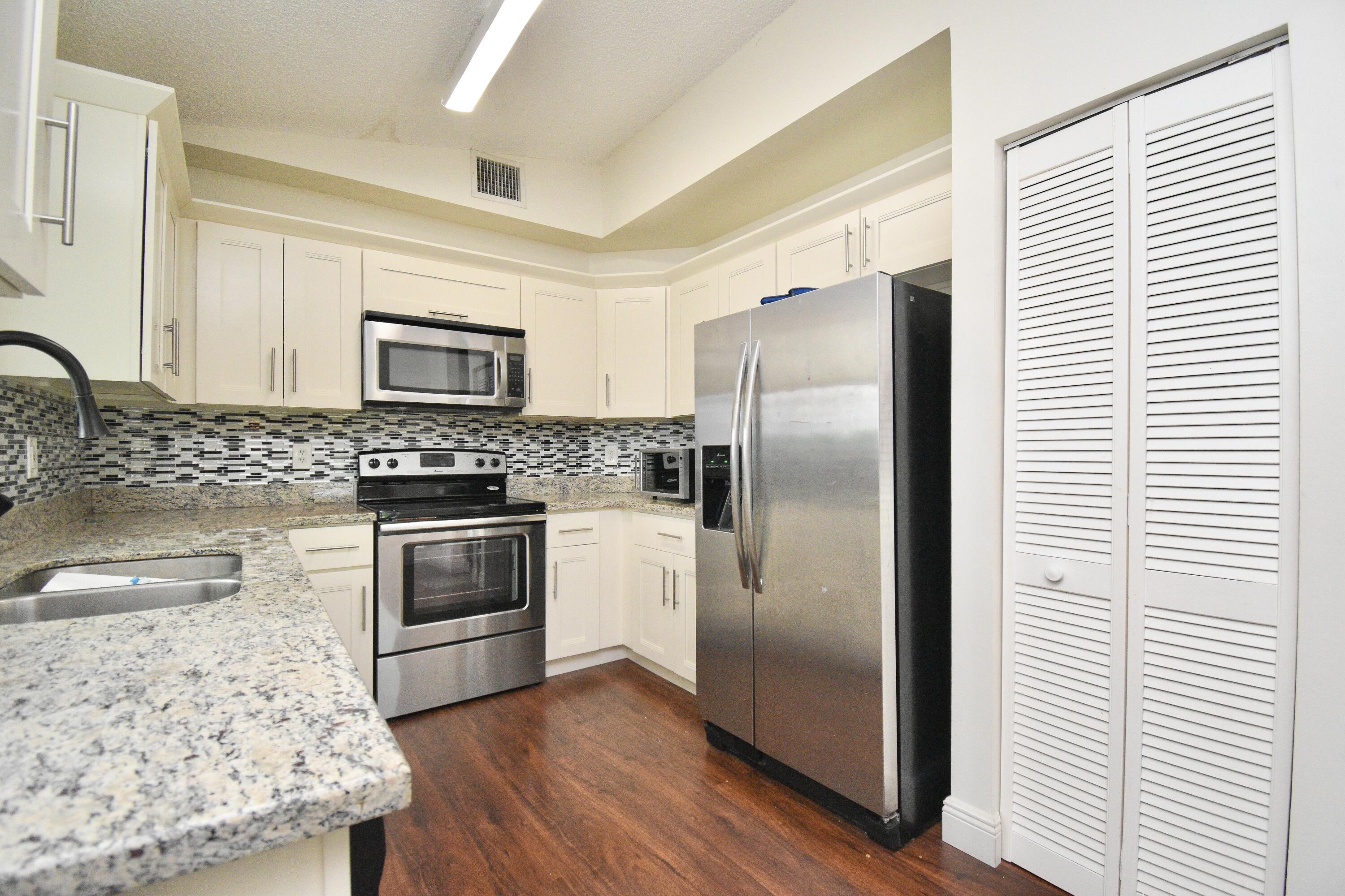 6053 Old Court Road, Unit 308 Boca Raton, FL 33433 - Photo 5 of 22 a kitchen with granite countertop a refrigerator stove and sink