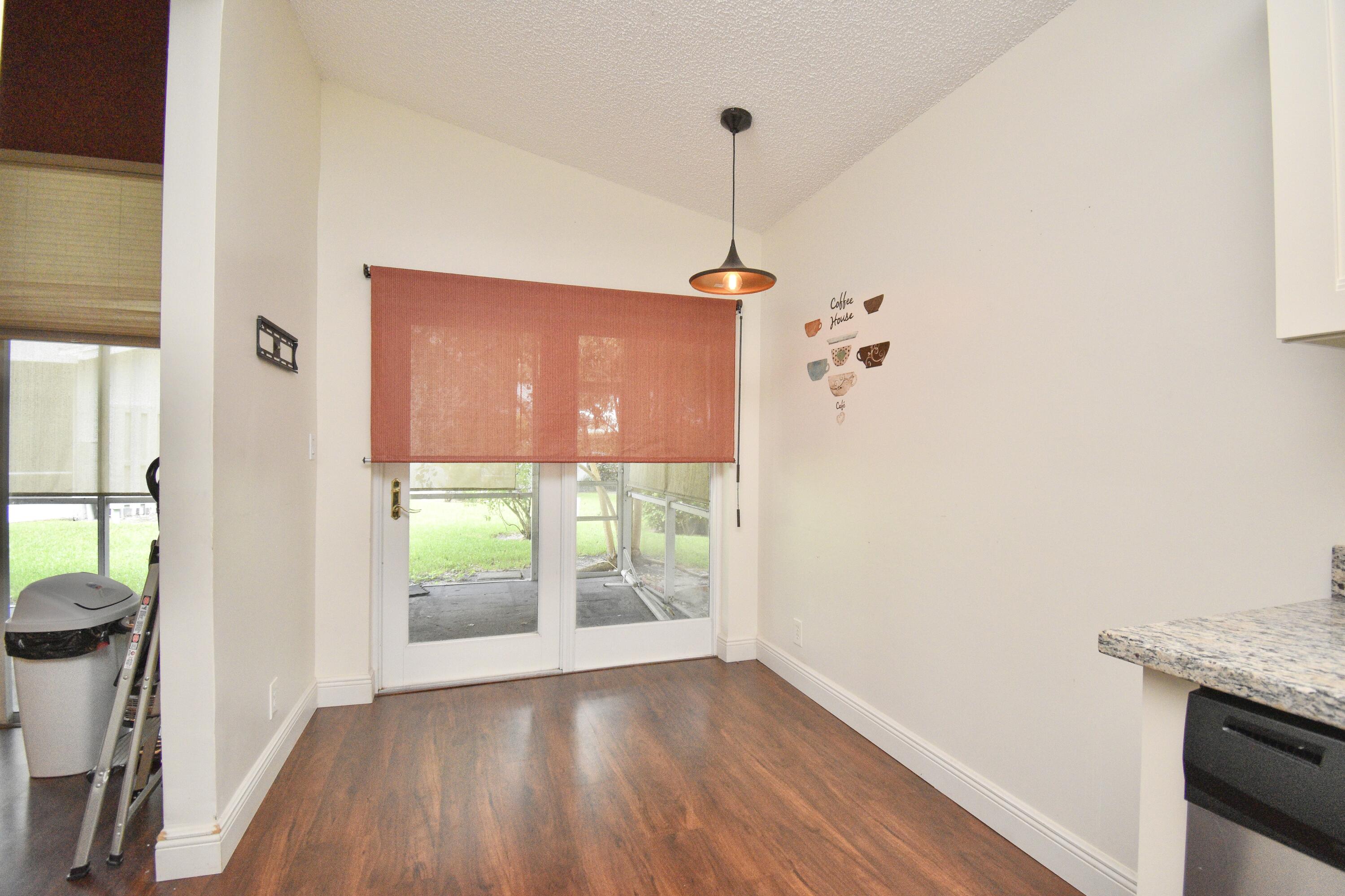 6053 Old Court Road, Unit 308 Boca Raton, FL 33433 - Photo 6 of 22 a view of a kitchen with a wooden floor and a window