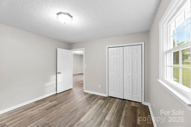 a view of a room with wooden floor and a window