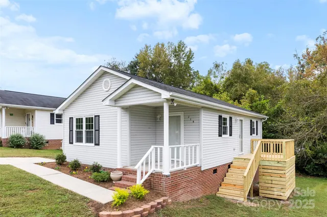 a view of a house with backyard and trees