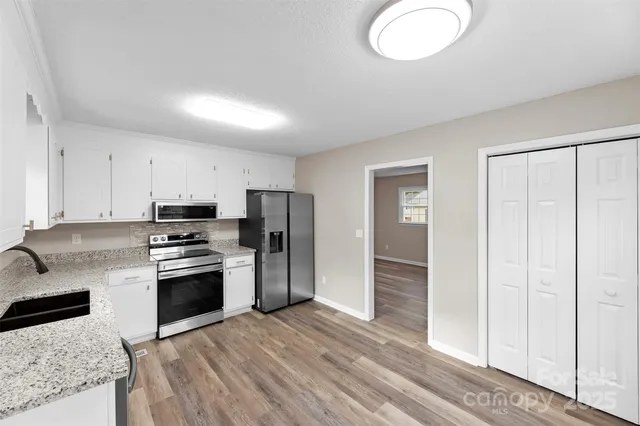 a kitchen with stainless steel appliances granite countertop a stove a refrigerator and a sink with granite countertops
