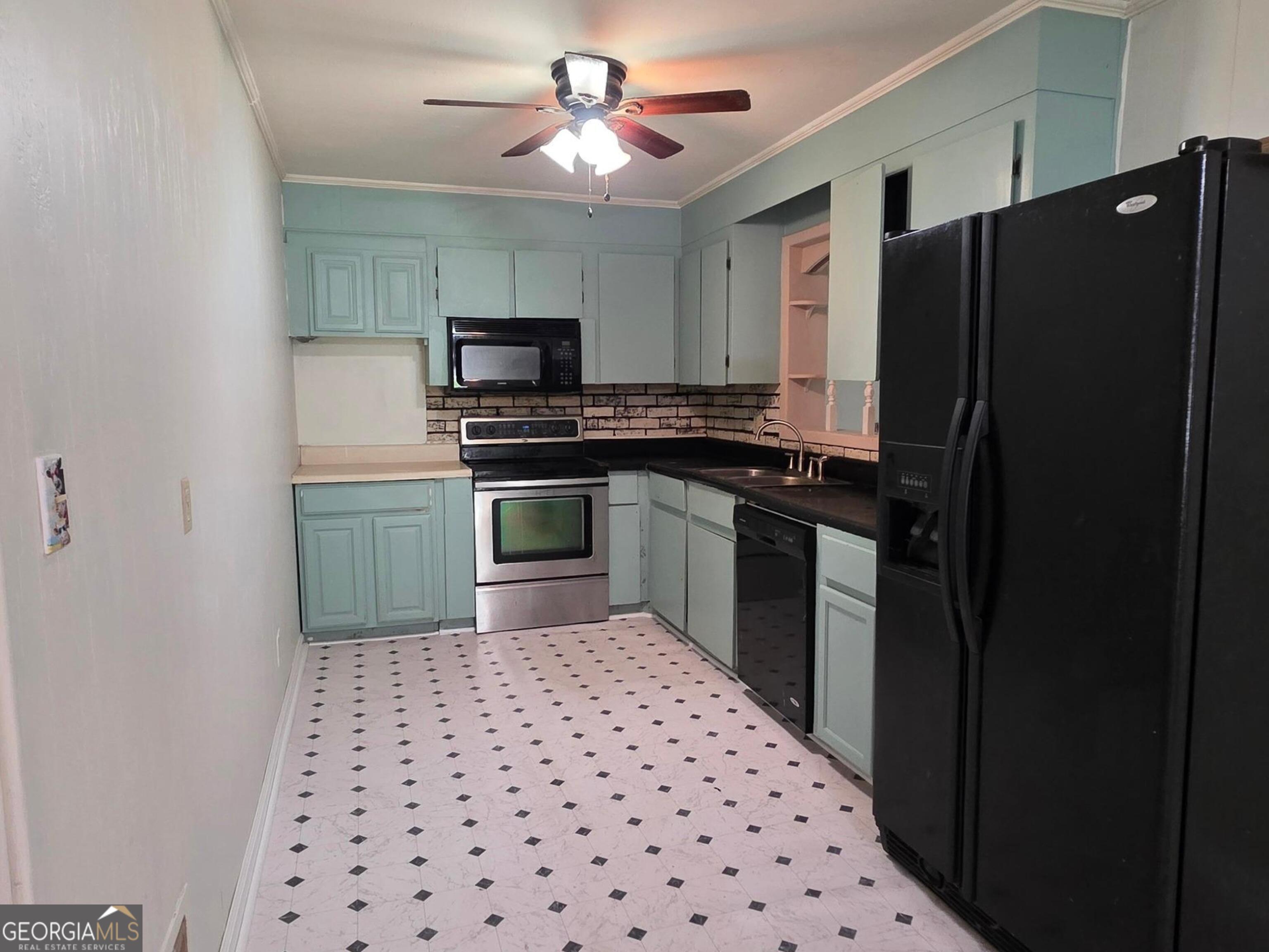 110 Lee Street Centerville, GA 31028 - Photo 5 of 16 a kitchen with a sink a refrigerator and a stove top oven with wooden floor