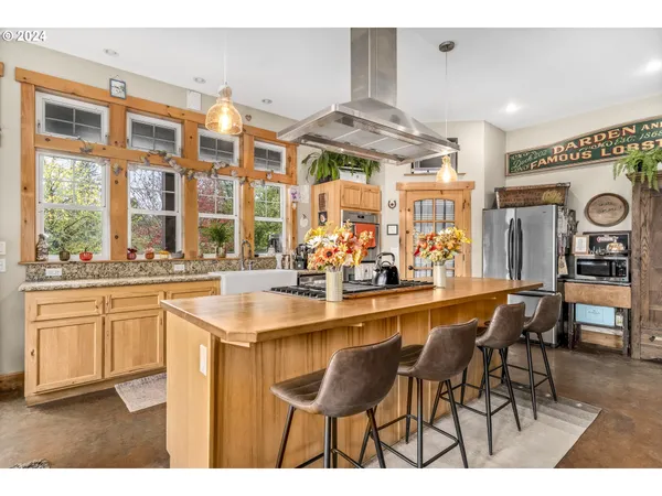 a kitchen area with stainless steel appliances kitchen island granite countertop a sink and cabinets