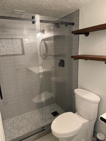 a white toilet next to a bathroom