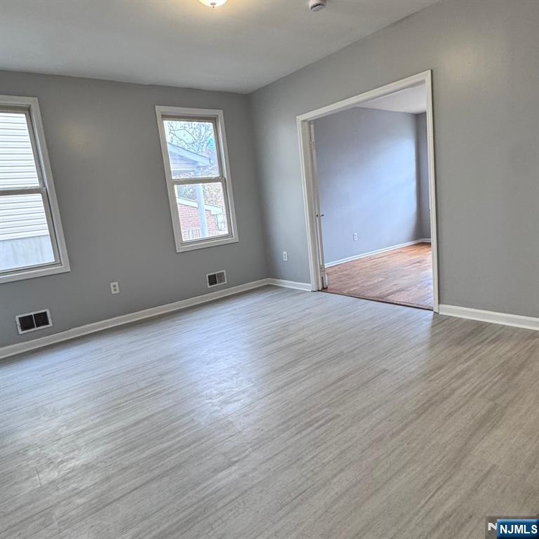 97 Clinton Place Newark, NJ 07108 - Photo 4 of 9 an empty room with wooden floor and windows