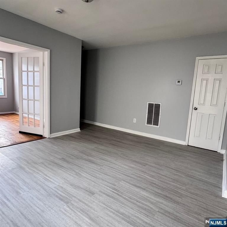97 Clinton Place Newark, NJ 07108 - Photo 5 of 9 a view of an empty room with wooden floor and windows