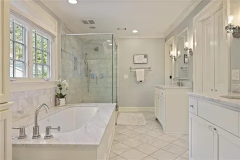 a en suite bathroom with a double vanity sink a mirror and a shower
