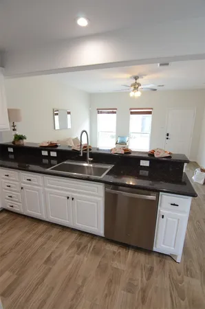 a kitchen with granite countertop a sink and cabinets