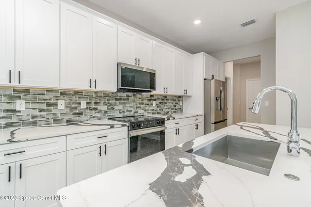 a large kitchen with stainless steel appliances a lot of counter space and wooden floor