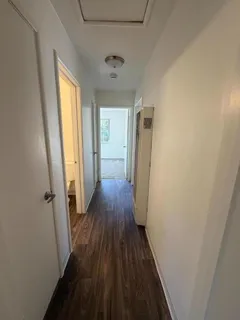 a view of a hallway with wooden floor and staircase