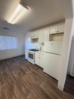 a kitchen with wooden floors and white appliances