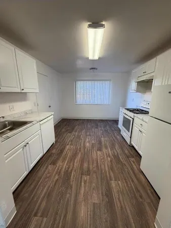 a kitchen with wooden floors and white appliances