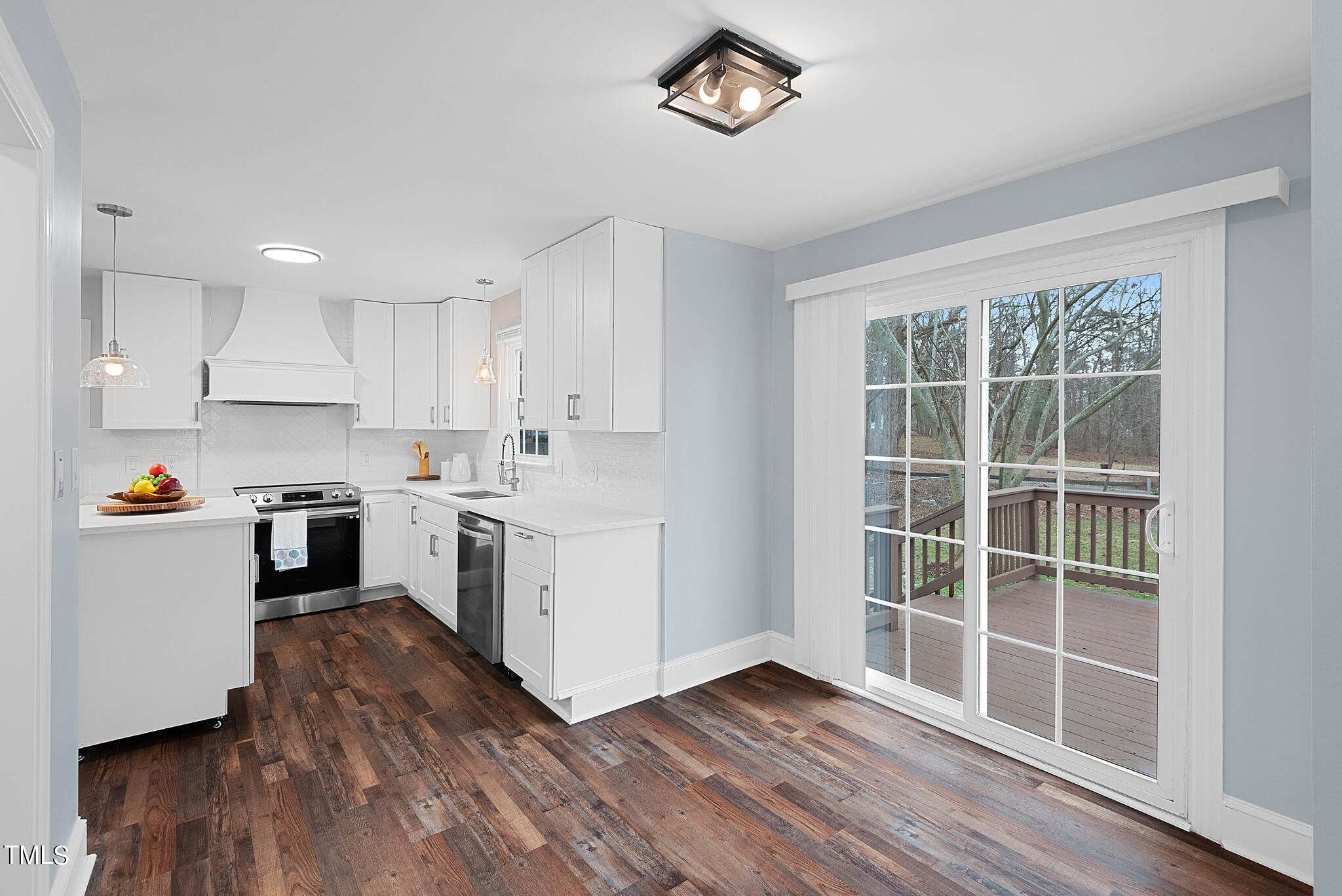 3012 Old Crews Road Raleigh, NC 27616 - Photo 13 of 34 a kitchen with wooden floors and white cabinets