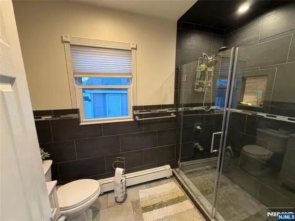 a bathroom with a toilet a sink and mirror